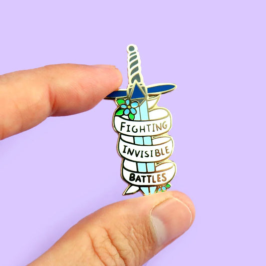 Jubly_Umph_Fighting_Invisible_battles_Lapel_pin_between_fingers
