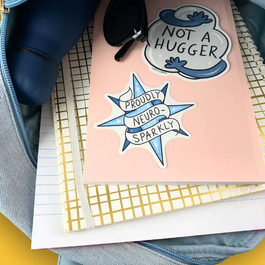 Jubly_umph_sticker_Proudly_neuro_sparkly_on_book