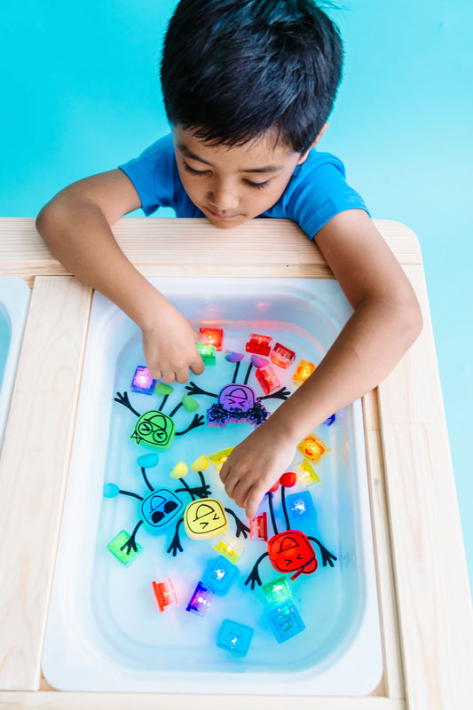 Jelly_stone_Boy_playing_wth_Glo_Pals_tub_of_brightly_coloured_glo_pal_cubes_and_characters_in_sensory_tub
