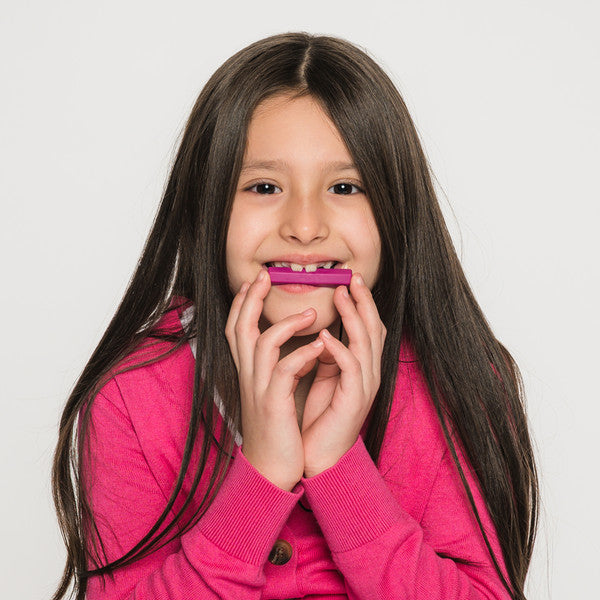 Ark_krypto_bite_chewable_tube_necklace_girl_chewing_and_smiling_chewing_magenta_necklace