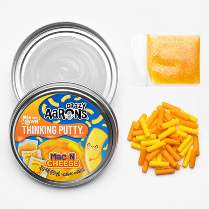 Crazy Aaron's Thinking Putty Mac N Cheese container with putty pieces on a white background