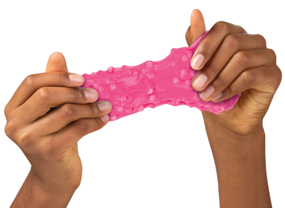 A pair of hands stretching a bright pink, bumpy, squishy slime toy against a solid white background. Crazy_Arrons_Sponge_Putty_packaging_