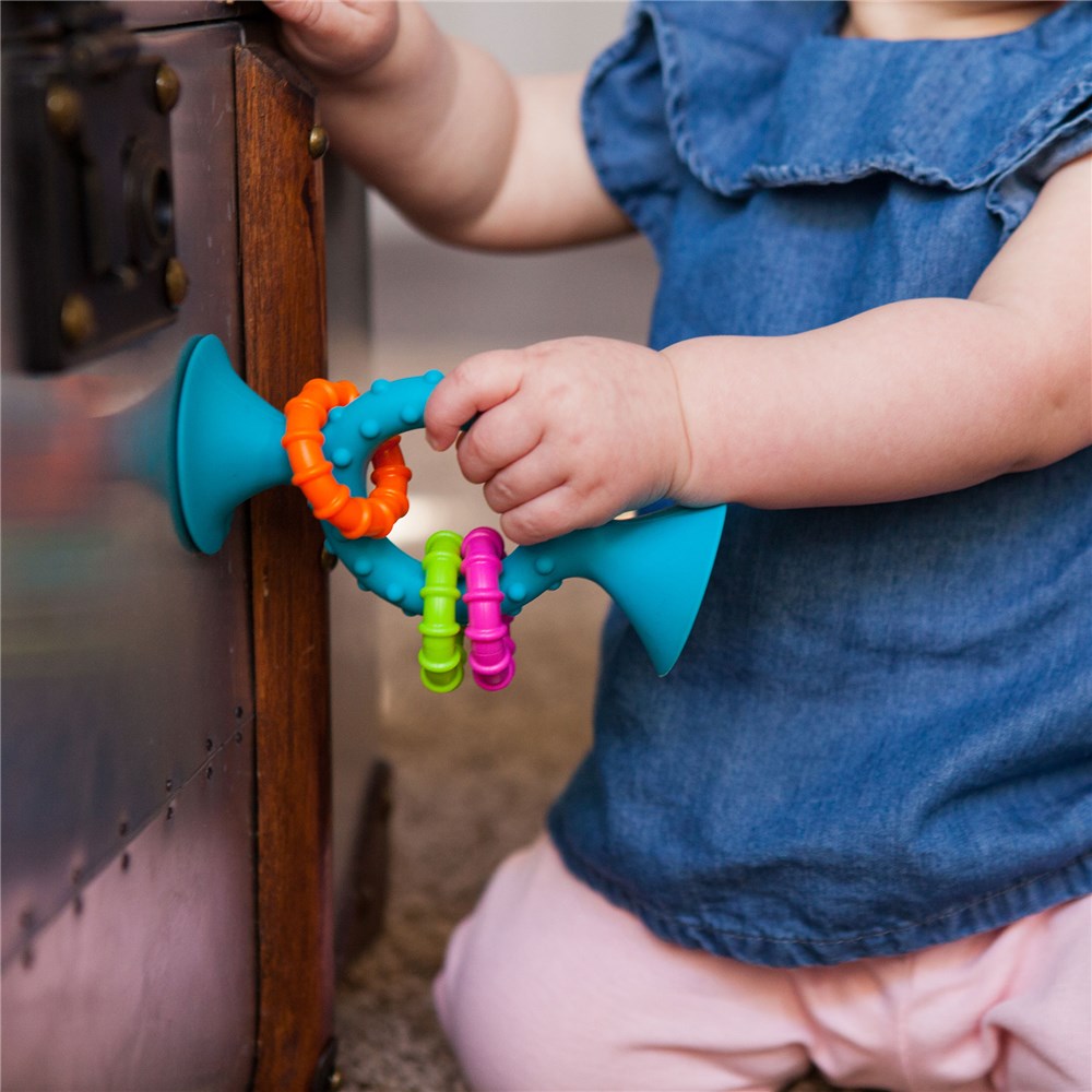 Fat_Brain_Toys_PipSquigzLoops-Teal_child_sticking_it_to_fridge