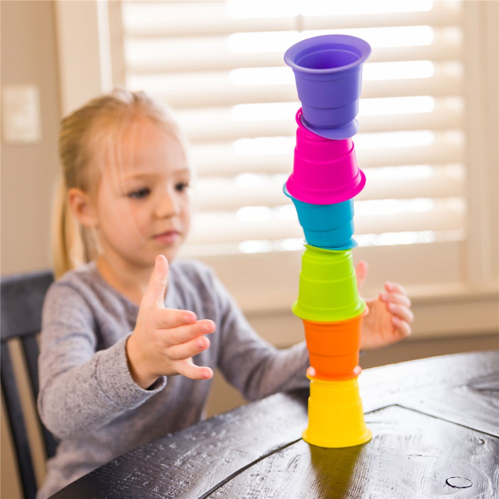 Fat_Brain_Toys_Suction_Kupz_girl_stacking_them_on_table