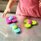 Fat_Brain_Toys_Whirly_Squigz_girl_playing_with_all_three_spinners