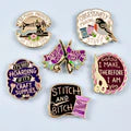 Collection of decorative buttons with various designs and text on a white background
