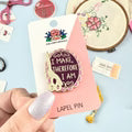 Hand holding a pink and white product with text, blurred background of cookies