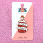 Jubly-Umph_Solution_of_strength_lapel_pin_on_cardboard_backing_and_sparkly_pink_paper