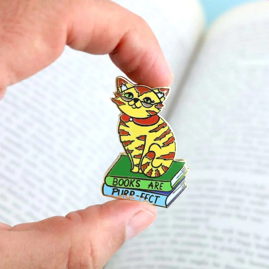 Jubly_Umph_Pin_Books_are_purrfect_lapel_pin_between_persons_fingers