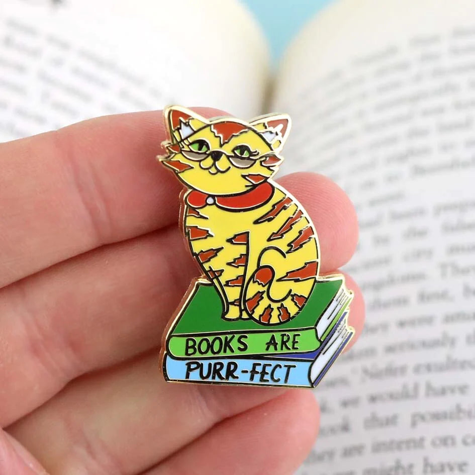 Jubly_Umph_Pin_Books_are_purrfect_lapel_pin_on_persons_hand