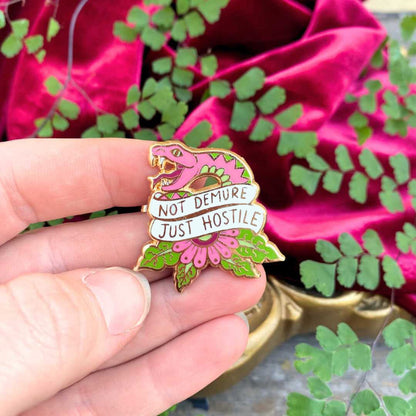 Jubly_Umph_not_demure_just_hostile_lapel_pin_in_hand