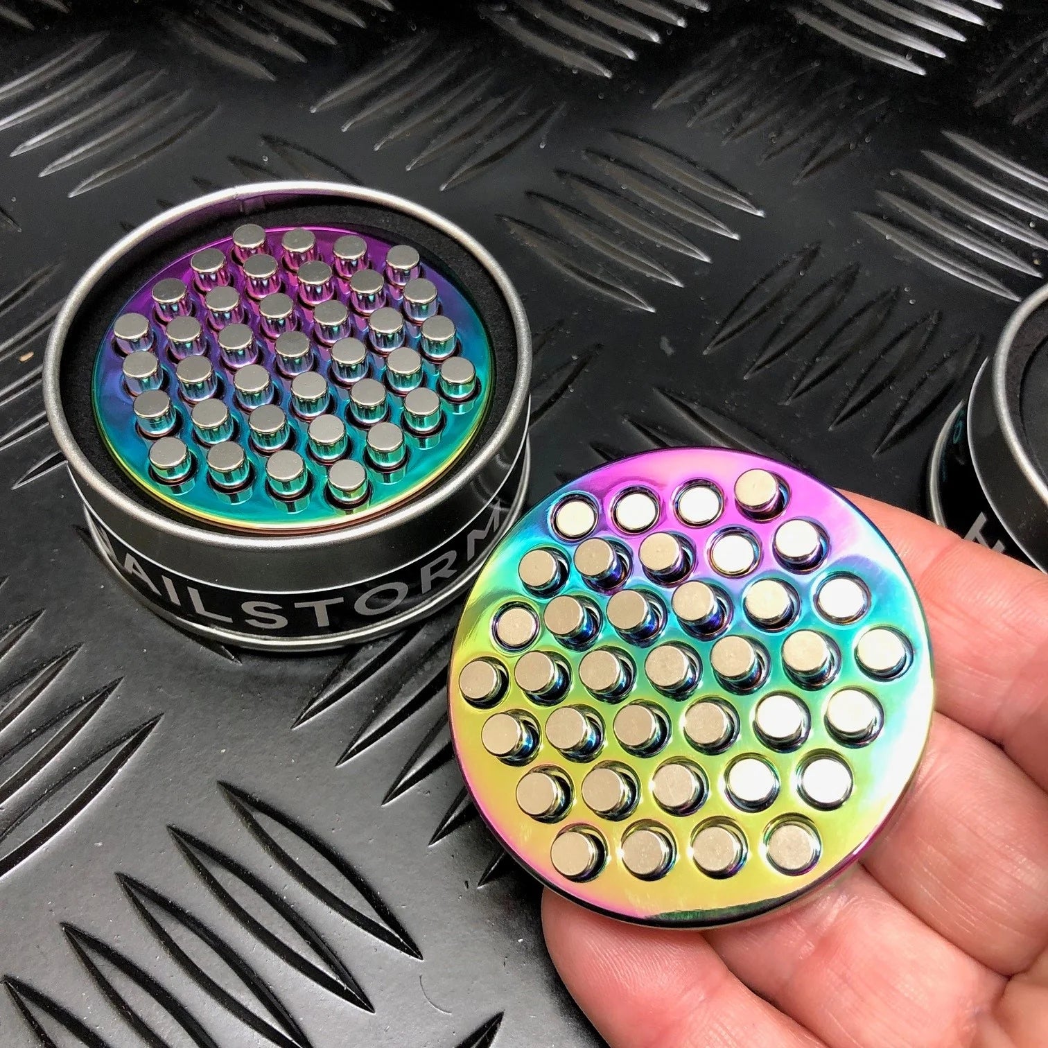 Kaiko_Hailstorm_metal_fidget_oil_slick_in_persons_hand.