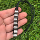 Kaiko_silk_worm_necklace_being_held_in_hand