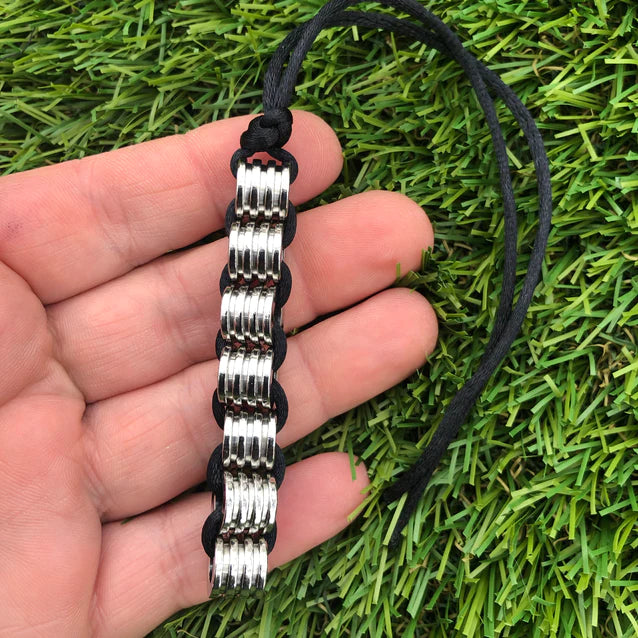 Kaiko_silk_worm_necklace_being_held_in_hand