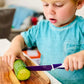 Kiddikutter_young_boy_cutting_cucumber_with_knife_purple