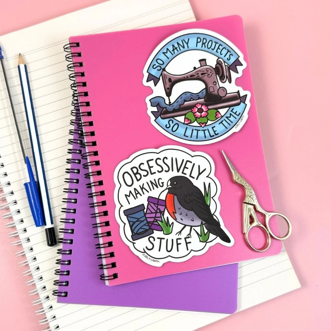 Pink notebook with sewing-themed stickers on a pink background. Sticker_Jubly_Umph__Obsessively_making_stuff_book