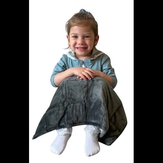 Child wearing a denim dress with a white background. Weighted_Lap_Pad_soft_grey_elizabeth_richards_girl_smiling
