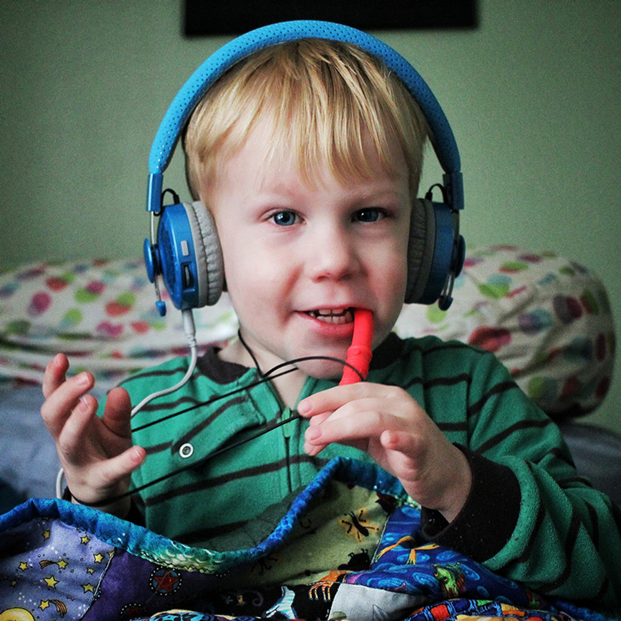 ARK's_Bite_Saber_Chew_boy_chewing_red_chew_with_ear_muffs_on