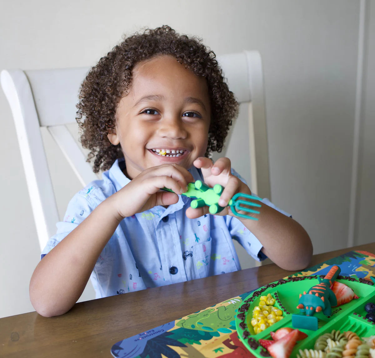 Child_using_dinosaur_cutlery_and_matching_plate_to_eat