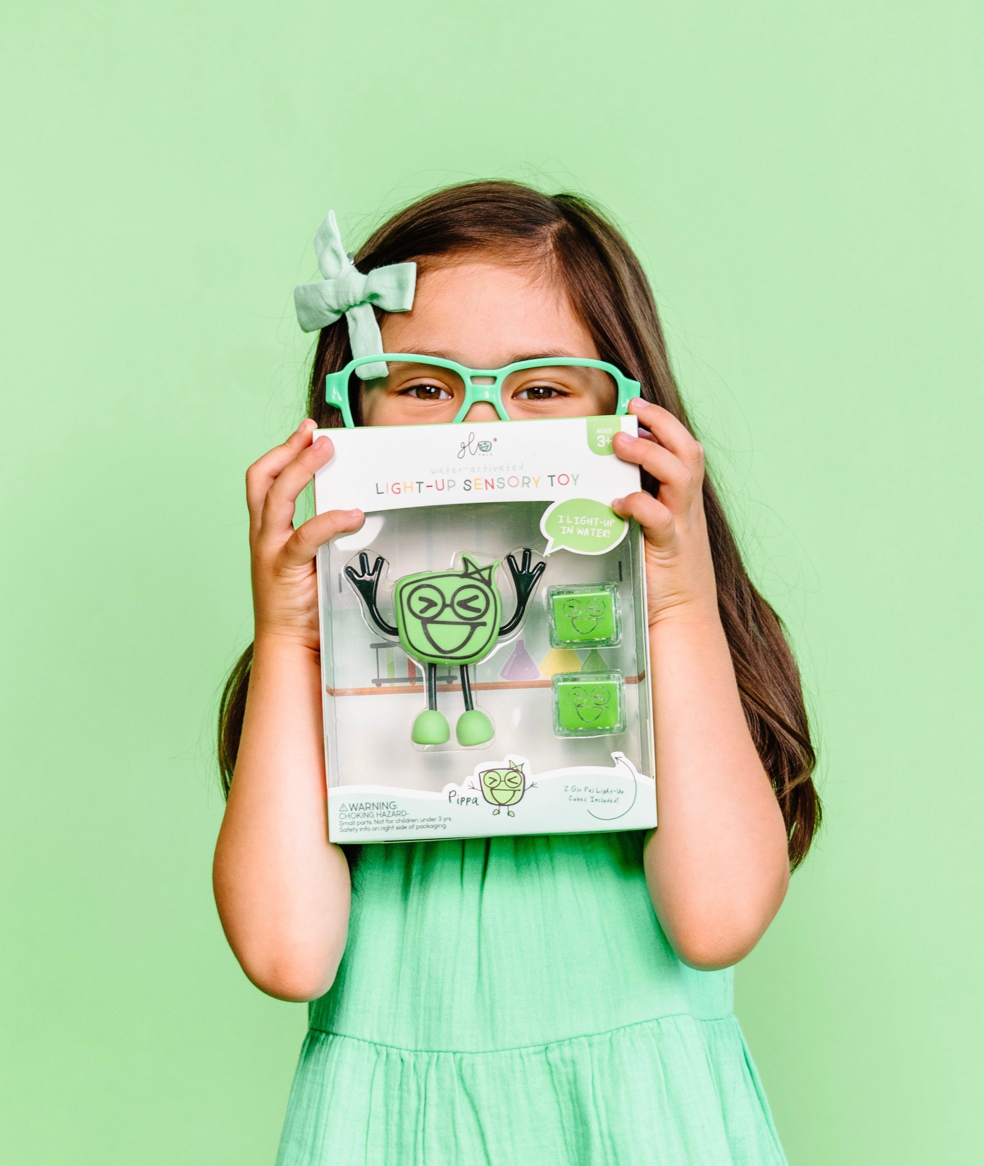 Jelly_stone_designs_Glo_pal_Character_Pippa_Green_in_packagin_held_by_girl_in_matching_green_glasses