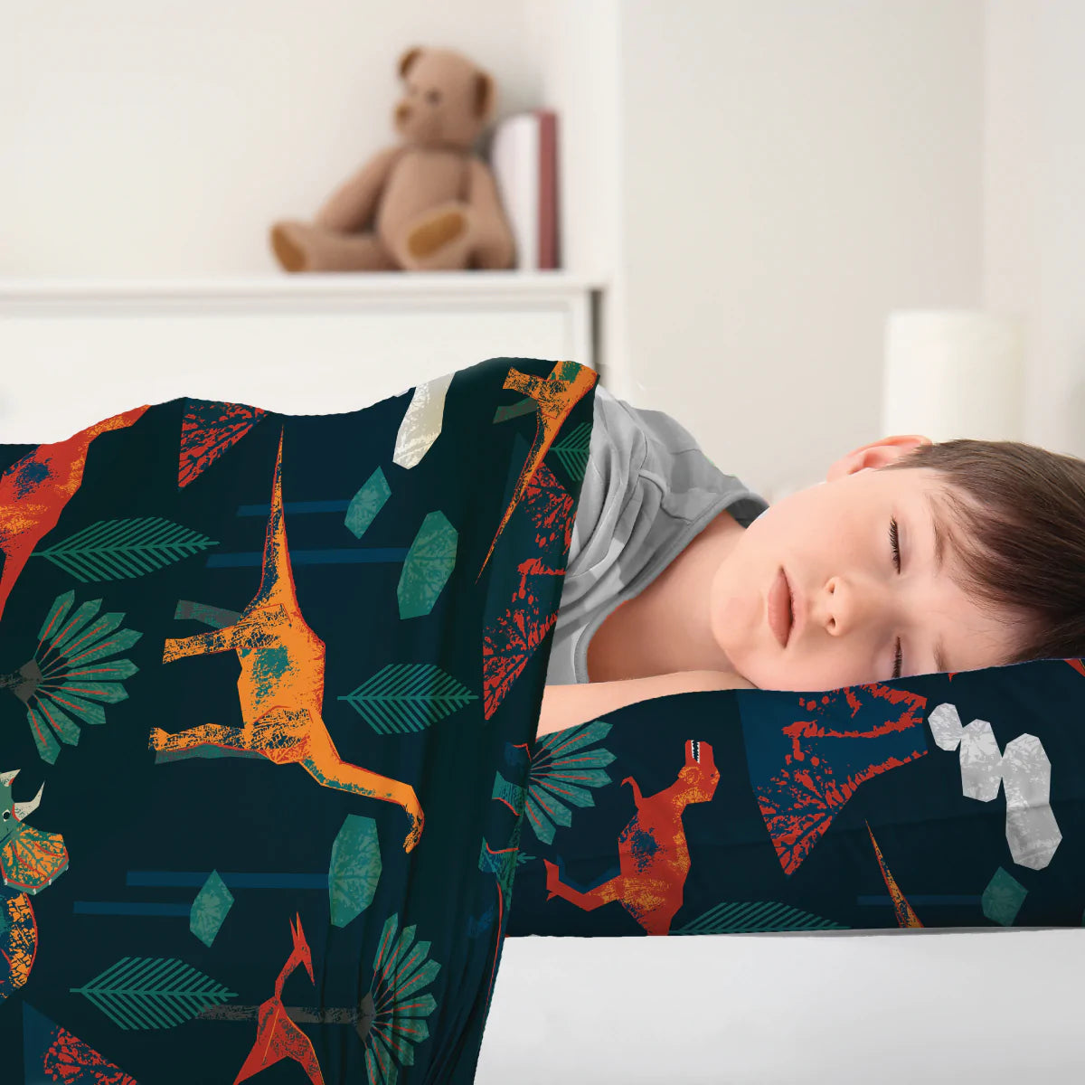 Boy_tucked_up_sleeping)in_Calmcare_Prehistoric_dinosaur_Sensory_Compression_Bed_Sheet