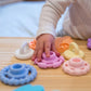 Baby_playing_with_Jelly_Stone_Designs_Rainbow_Stacker_and_Teether_Toy_pieces_all_spread_out